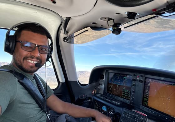 Phil Alves at the controls of a small plane, wearing a headset